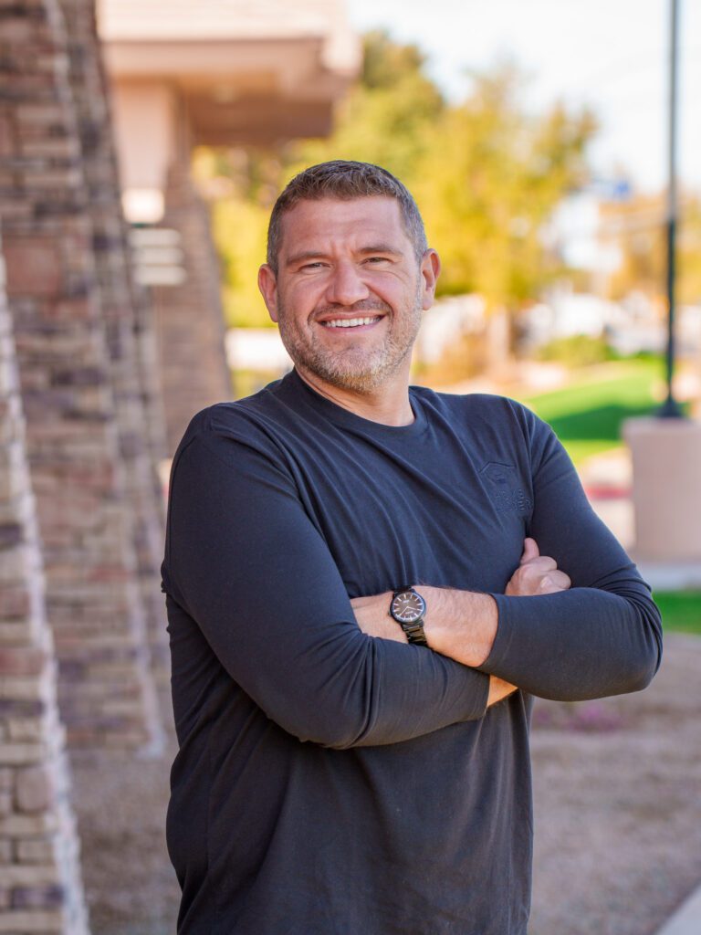 Travis Bohling posing in front of Home Ladder Property Management office.